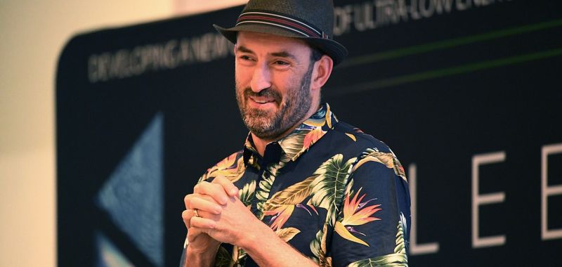 Exciton Science Chief Investigator Jared Cole addressing an audience while wearing a short sleeved shirt and a trilby hat