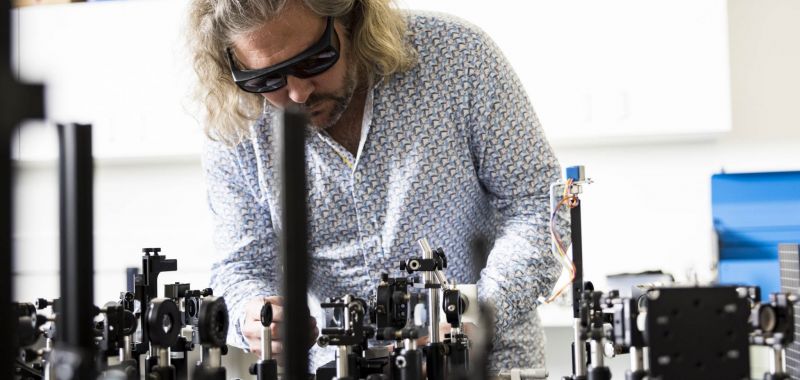 Professor Tim Schmidt wearing protective goggles working in a laser equipment laboratory at UNSW Sydney.