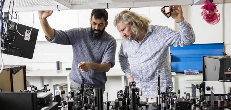 Shyamal Prasad (left) and Tim Schmidt (right) working in a laser lab at UNSW in Sydney