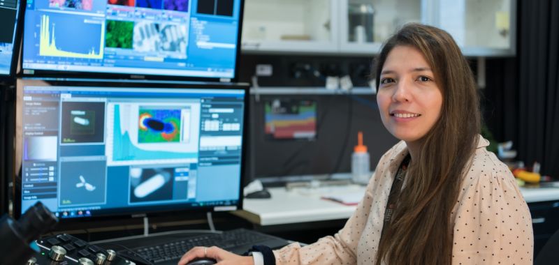 PhD student Lesly Melendez sitting in front of a computer screen in a laboratory