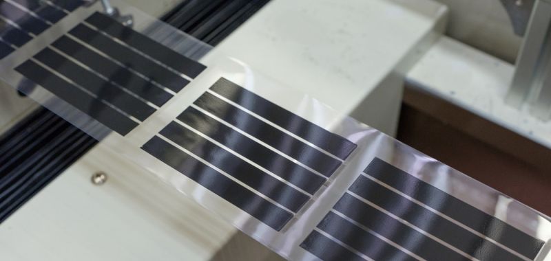 Semi-transparent printed solar cells are shown in front of a light metallic surface