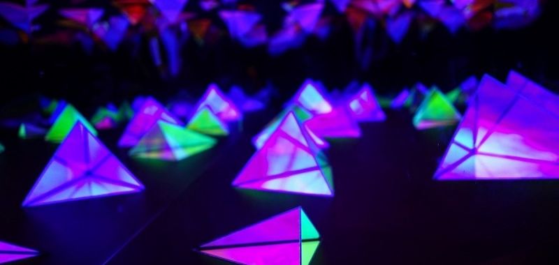 An image of triangular graphics in green and purple fluorescent colours