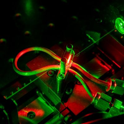 An image showing a green laser beam in an Exciton Science laboratory