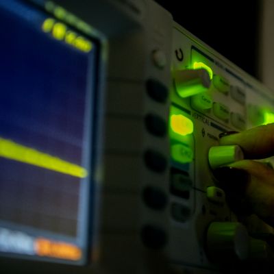 An image of a hand operating the dials of equipment located in the laser lab at University of Melbourne's School of Chemistry
