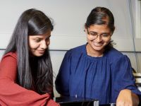 Elizabeth Thomas (right) standing with Anchal Yadav (left) in a laboratory at Monash University
