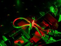 An image showing a green laser beam in an Exciton Science laboratory
