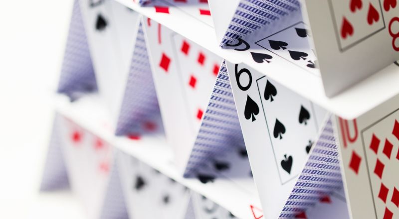 A close up image of a house of cards made from a deck of playing cards